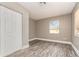 An empty bedroom displays plank flooring, neutral colored walls, a closet, and windows with blinds at 2078 Keyes Ln, Deltona, FL 32738