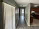 Well-lit hallway with wood-look flooring leading to the kitchen, offering a seamless flow at 2078 Keyes Ln, Deltona, FL 32738