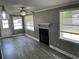 Living room with a fireplace, ceiling fan, and two windows, offering a cozy space at 2078 Keyes Ln, Deltona, FL 32738