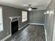 Cozy living room with a decorative fireplace, ceiling fan, and natural light from multiple windows at 2078 Keyes Ln, Deltona, FL 32738