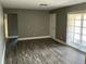 Spacious living room with hardwood floors, fresh paint, a white door, and multiple windows at 2078 Keyes Ln, Deltona, FL 32738