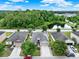 An aerial view features the home with solar panels, a paved driveway, and mature landscaping in a serene community at 2216 Sequoia Way, Davenport, FL 33896