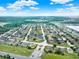 An expansive aerial view captures a residential community with manicured lawns, surrounding greenery, and community gate at 2216 Sequoia Way, Davenport, FL 33896