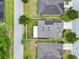 An aerial view of a home featuring solar panels and a screen enclosed patio, nicely landscaped and surrounded by trees at 2216 Sequoia Way, Davenport, FL 33896