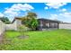 Landscaped backyard featuring a screened-in lanai and a pristine white fence at 2216 Sequoia Way, Davenport, FL 33896