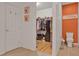 Bathroom featuring a doorway to walk-in closet, orange accent wall and white door at 2216 Sequoia Way, Davenport, FL 33896