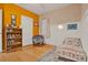 A serene bedroom featuring wainscoting, stylish wallpaper, and a cozy reading corner at 2216 Sequoia Way, Davenport, FL 33896