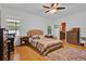 Warm bedroom with wood floors, a comfortable bed, and good natural lighting at 2216 Sequoia Way, Davenport, FL 33896