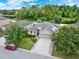 Aerial view of a charming home with a well-kept lawn, driveway, and solar panels at 2216 Sequoia Way, Davenport, FL 33896