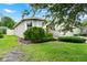 Landscaped front yard shows lush green lawn and mature plantings around the perimeter of the home at 2216 Sequoia Way, Davenport, FL 33896