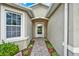 Covered front entry and walkway landscaped with mulch and flowers lead to the front door at 2216 Sequoia Way, Davenport, FL 33896