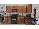 Well-equipped kitchen featuring granite countertops, wood cabinets, and modern appliances at 2216 Sequoia Way, Davenport, FL 33896