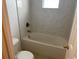 Bathroom featuring a tub with marble tile surround, toilet, and neutral paint at 2299 Rock Dr, Poinciana, FL 34759