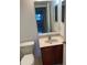 Bathroom featuring a single sink vanity, toilet, mirror, and neutral paint at 2299 Rock Dr, Poinciana, FL 34759