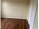A simple bedroom with dark laminate wood floors and white closet doors provides a minimalist aesthetic at 2299 Rock Dr, Poinciana, FL 34759