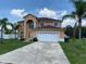 Inviting two-story home with a white garage door, manicured lawn, and beautiful landscaping at 2299 Rock Dr, Poinciana, FL 34759