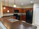 A spacious kitchen with an island with sink, featuring dark cabinetry and black appliances at 2299 Rock Dr, Poinciana, FL 34759