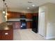 A spacious kitchen featuring tile flooring, dark cabinetry, and black appliances at 2299 Rock Dr, Poinciana, FL 34759
