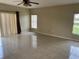 Open-concept living room with tile floors, large windows, and sliding glass doors at 2299 Rock Dr, Poinciana, FL 34759