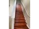 A staircase features laminate wood steps complemented by white banisters and a neutral-toned wall at 2299 Rock Dr, Poinciana, FL 34759