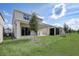 A view of the back of the property featuring a covered patio and a large, well-maintained lawn at 2354 Emerald Springs Dr, Apopka, FL 32712