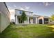 Lush backyard featuring a covered patio, mature trees, and ample space for outdoor activities at 2354 Emerald Springs Dr, Apopka, FL 32712