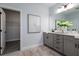 Well-lit bathroom with double vanity, a walk-in closet, and neutral tones, creating a serene and functional space at 2354 Emerald Springs Dr, Apopka, FL 32712