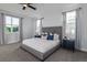 Spacious primary bedroom with a stylish bed, large windows, and contemporary bedside tables with lamps at 2354 Emerald Springs Dr, Apopka, FL 32712