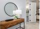 Entryway features decorative wood console table, round mirror, and open doorway to bathroom with pedestal sink at 2354 Emerald Springs Dr, Apopka, FL 32712