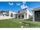 A view of the back of the property featuring a covered patio and a large, well-maintained lawn at 2354 Emerald Springs Dr, Apopka, FL 32712