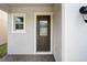 A stylish front door with glass panel and black hardware, complemented by an adjacent window and sconce at 2354 Emerald Springs Dr, Apopka, FL 32712