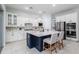 Kitchen with white cabinets, a navy island with seating, and stainless steel appliances at 2354 Emerald Springs Dr, Apopka, FL 32712