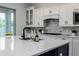 Bright kitchen features white cabinets, a spacious island, stainless steel appliances, and stylish backsplash at 2354 Emerald Springs Dr, Apopka, FL 32712