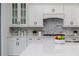 Kitchen featuring white cabinets, quartz counters and marble backsplash at 2354 Emerald Springs Dr, Apopka, FL 32712