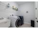 Well-organized laundry room with modern washer and dryer, utility sink, and shelving at 2354 Emerald Springs Dr, Apopka, FL 32712