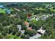 Aerial view of community with golf course, tennis courts, and a home with mature trees at 25974 High Hampton Cir, Sorrento, FL 32776
