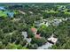 Aerial view of community with golf course, tennis courts, and a home with mature trees at 25974 High Hampton Cir, Sorrento, FL 32776
