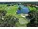 Scenic aerial view showcasing the golf course with its pristine fairways and a tranquil lake at 25974 High Hampton Cir, Sorrento, FL 32776