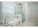 Elegant bathroom features a soaking tub, marble finishes, and a glass-enclosed shower at 25974 High Hampton Cir, Sorrento, FL 32776