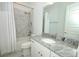 Bathroom featuring marble tile, granite counters, a shower/tub combination, and white cabinets at 25974 High Hampton Cir, Sorrento, FL 32776