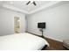 This airy bedroom features an en suite bath, TV, ceiling fan, and hardwood floors at 25974 High Hampton Cir, Sorrento, FL 32776