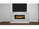 Modern electric fireplace featuring contemporary tile work, a large mounted TV, and hardwood floors at 25974 High Hampton Cir, Sorrento, FL 32776