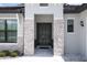 Elegant front entrance featuring double doors, stone accents, stylish lighting, and decorative plants at 25974 High Hampton Cir, Sorrento, FL 32776