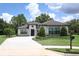 Charming single-story home with manicured lawn, neatly trimmed hedges, and a stone-paved driveway at 25974 High Hampton Cir, Sorrento, FL 32776