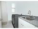 Laundry room featuring stainless steel washer and dryer, sink with granite countertop, and white cabinets at 25974 High Hampton Cir, Sorrento, FL 32776