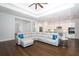 Open-concept living room featuring a sectional sofa, hardwood floors, and seamless flow into the kitchen at 25974 High Hampton Cir, Sorrento, FL 32776