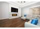 Beautiful living room with hardwood floors, a modern electric fireplace, and a comfortable sectional sofa at 25974 High Hampton Cir, Sorrento, FL 32776