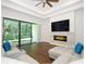 Cozy living room featuring hardwood floors, modern fireplace, a ceiling fan, and sliding glass doors at 25974 High Hampton Cir, Sorrento, FL 32776