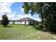 Back view of the house, featuring clean lines, tidy landscaping, and large backyard at 25974 High Hampton Cir, Sorrento, FL 32776