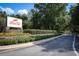 Community entrance sign with stone accents and manicured flower beds along the road at 25974 High Hampton Cir, Sorrento, FL 32776